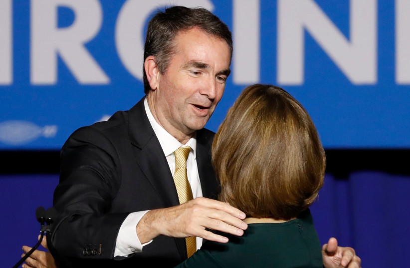 Democratic candidate for governor Ralph Northam embraces his wife Pam as he addresses supporters after his election night victory at the campus of George Mason University in Fairfax, Virginia, November 7, 2017. (photo credit: AARON P. BERNSTEIN/ REUTERS)
