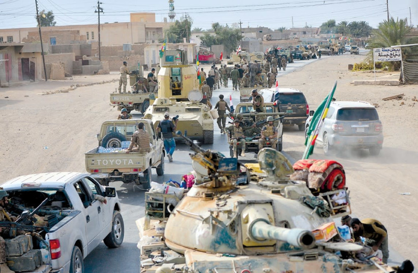 Vehicles of the Shi’ite Popular Mobilization Forces move through Al-Qaim after recapturing the Iraqi city on November 3 (photo credit: REUTERS)