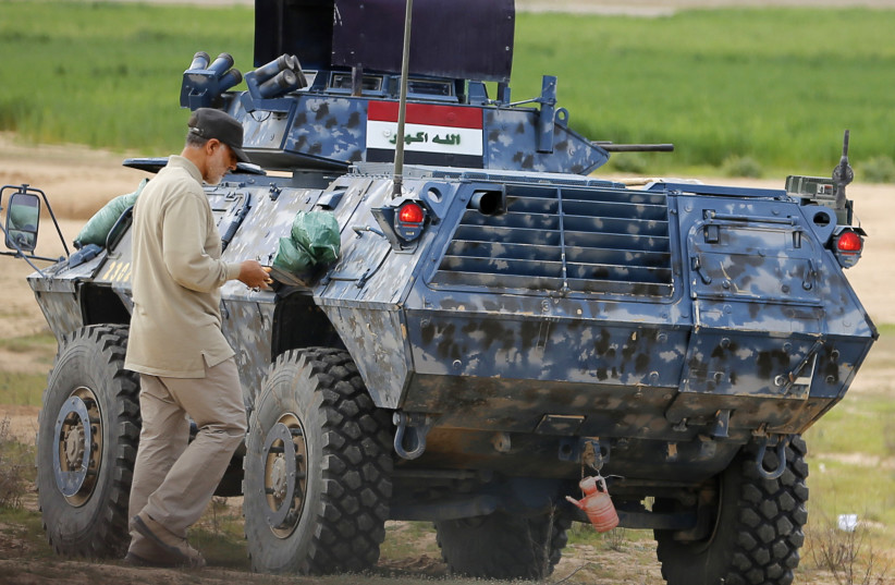 Iranian Revolutionary Guard Commander Qassem Soleimani walks near an armored vehicle at the frontline during offensive operations against Islamic State militants in Iraq (photo credit: COURTESY VIA REUTERS)