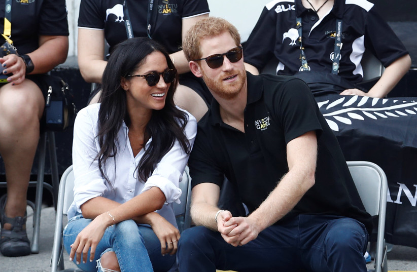 Britain's Prince Harry sits with fiance, actress Meghan Markle to watch a wheelchair tennis event during the Invictus Games (photo credit: MARK BLINCH/ REUTERS)