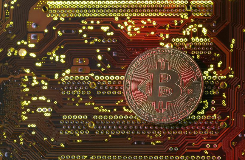 A copy of bitcoin standing on PC motherboard is seen in this illustration picture (photo credit: REUTERS/ DADO RUVIC)