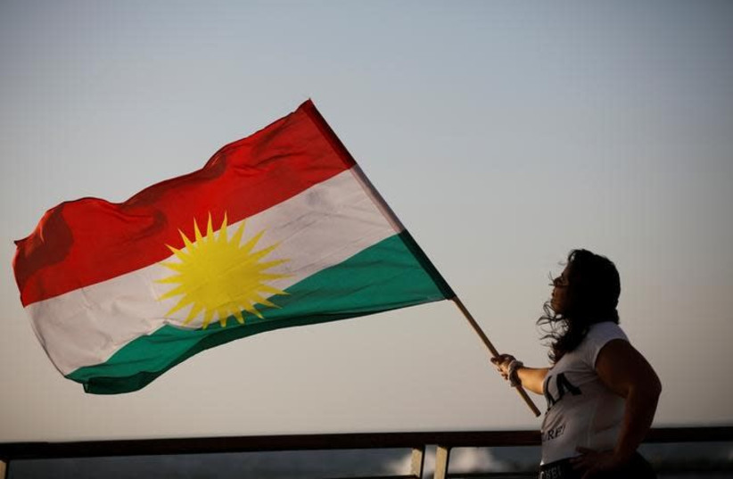 An Israeli woman of Kurdish origin holds a Kurdish flag (credit: REUTERS/AMIR COHEN)