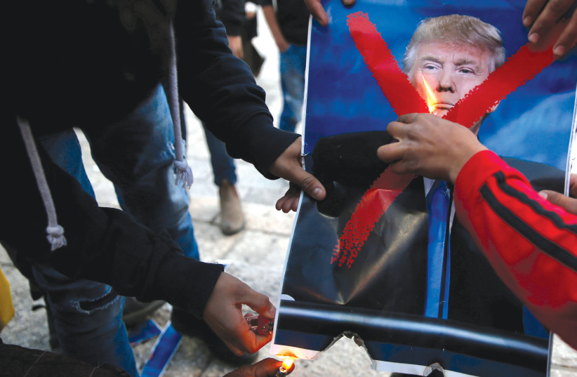 PALESTINIANS BURN a picture of US President Donald Trump as they take part in a protest against Trump’s decision to recognize Jerusalem as the capital of Israel, near Damascus Gate in Jerusalem’s Old City, earlier this week (photo credit: AMMAR AWAD/REUTERS)