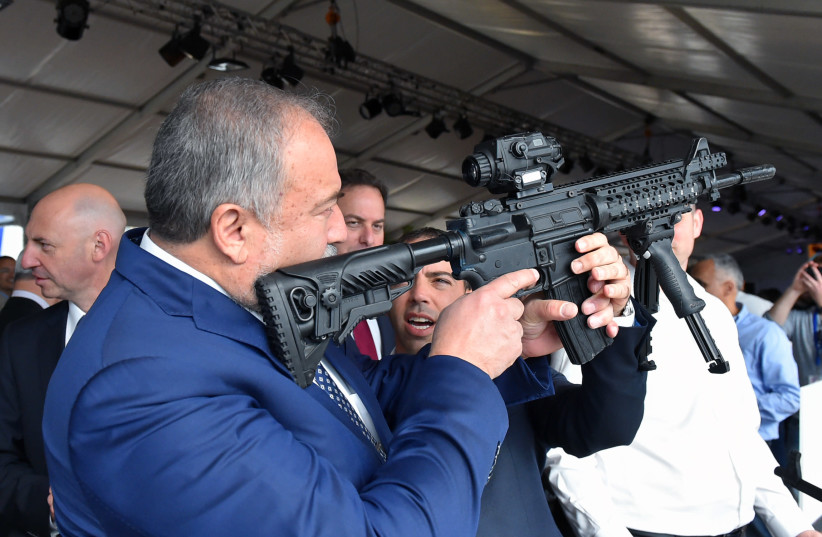 Defense Minister Avigdor Liberman holds a weapon during a visit to Sderot (photo credit: ARIEL HERMONI / DEFENSE MINISTRY)