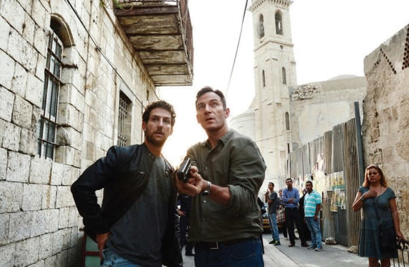 JASON ISAACS (right) and Ori Pfeffer on the set of the US TV show ‘Dig.’  The show, produced by NBCUniversal for its USA Network, stopped filming in Israel during the June 2014 Gaza war and completed filming in Croatia and New Mexico.  (photo credit: RONEN AKERMAN/USA NETWORK)