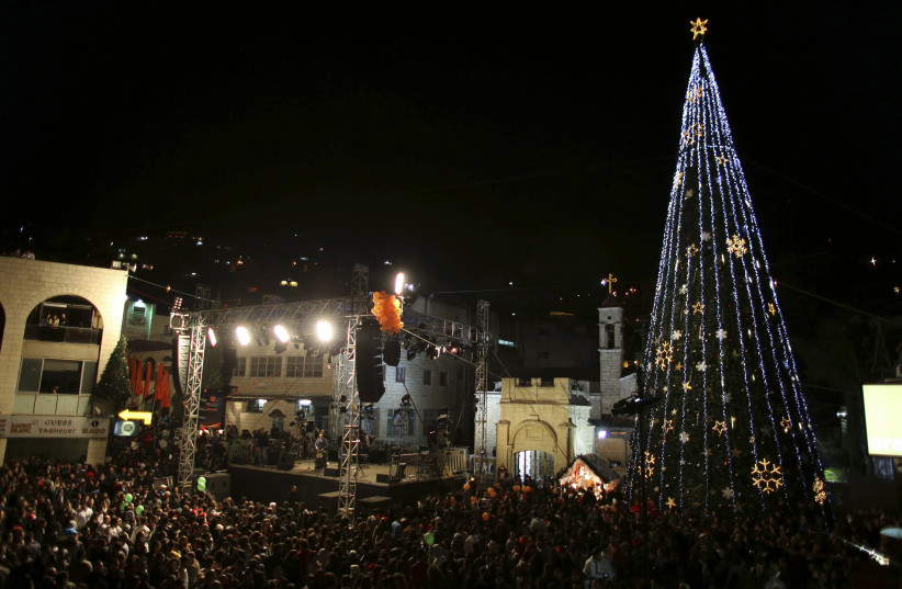 People attend a Christmas tree lighting ceremony in Nazareth (photo credit: AMMAR AWAD/REUTERS)