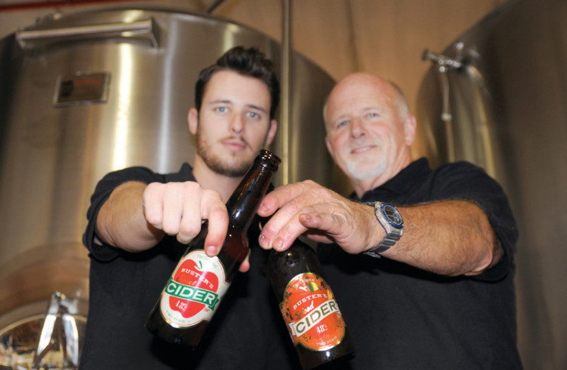MATT NEILSON (left) and father Denny of Buster’s Brewery, with bottles of their apple cider (photo credit: Courtesy)