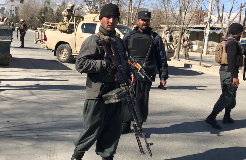 Afghan policemen stand guard at the site of a blast in Kabul, Afghanistan December 28, 2017 (photo credit: REUTERS)