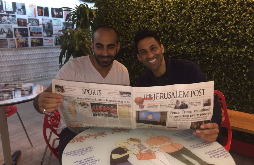 Israeli comedians Yohay Sponder (L) and Shahar Hasson (R) read 'The Jerusalem Post' (credit: YOCHEVED LAUFER)