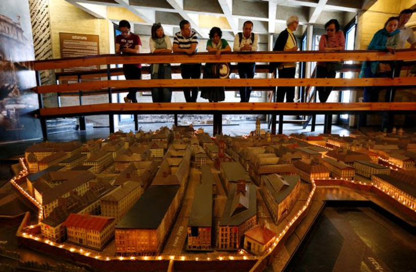 Tourists look at a model of the Warsaw Ghetto displayed at the ''From Holocaust to Revival'' museum in Kibbutz Yad Mordechai in southern Israel May 4, 2016.  (credit: REUTERS/AMIR COHEN)