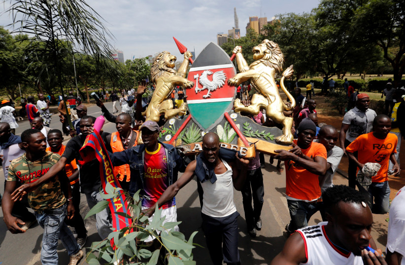 Supporters of Kenyan opposition leader Raila Odinga of the National Super Alliance (NASA) coalition gesture as they walk along a street ahead of his planned swearing-in ceremony as the president of the People’s Assembly in Nairobi, Kenya (photo credit: THOMAS MUKOYA / REUTERS)