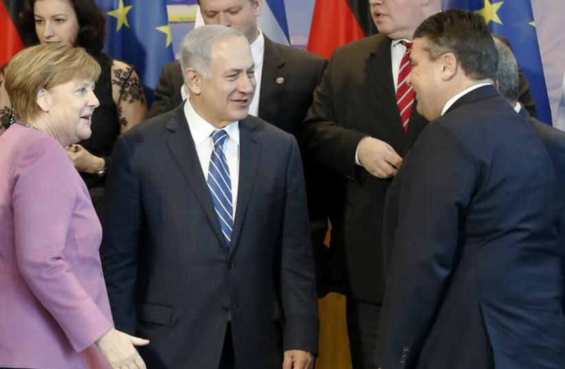 German Chancellor Angela Merkel (L-R) and Israeli Prime Minister Benjamin Netanyahu talk to German Economy Minister Sigmar Gabriel before they pose for a group picture with their delegations at the Chancellery in Berlin, Germany, February 16, 2016 (photo credit: FABRIZIO BENSCH / REUTERS)