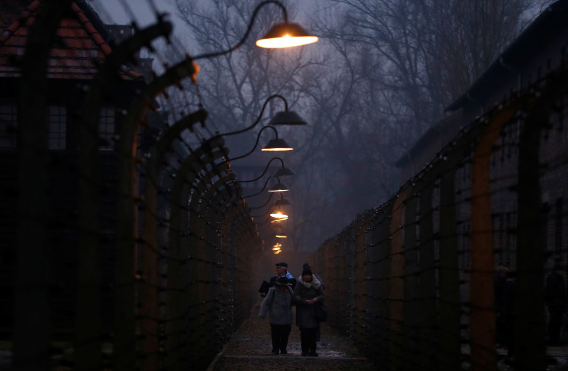 Survivors and guests walk inside the barbed wire fences at Auschwitz, during ceremonies marking the 73rd anniversary of the liberation of the camp, in Oswiecim, Poland, January 27, 2018. (photo credit: REUTERS/KACPER PEMPEL)