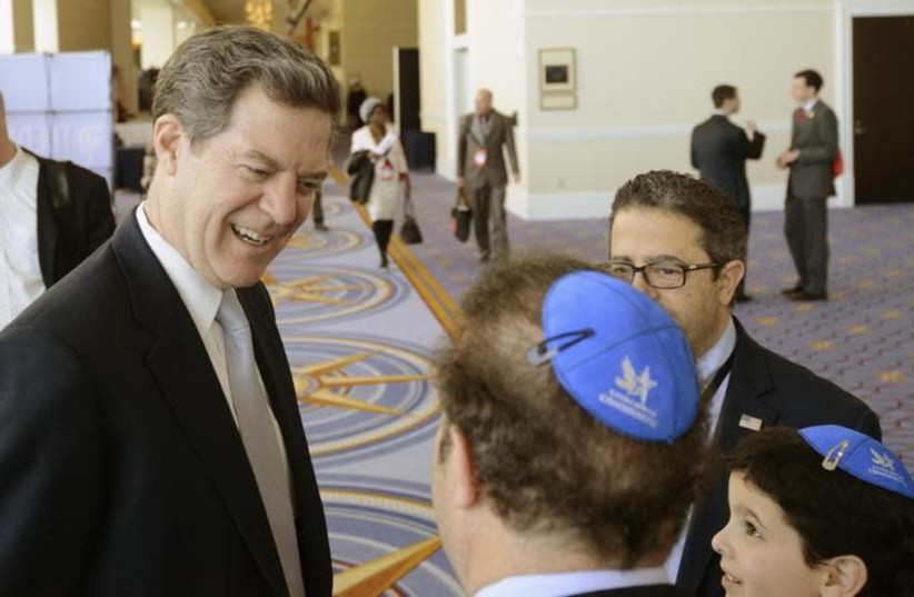 Then-Kansas Gov. Sam Brownback chats with a group from the Young Jewish Conservatives at the Conservative Political Action Conference in Maryland in 2015 (photo credit: MIKE THEILER/REUTERS)