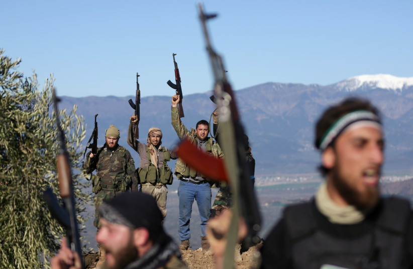 Turkish-backed Free Syrian Army fighters react as they hold their weapons near the city of Afrin, Syria February 19, 2018. (photo credit: REUTERS)