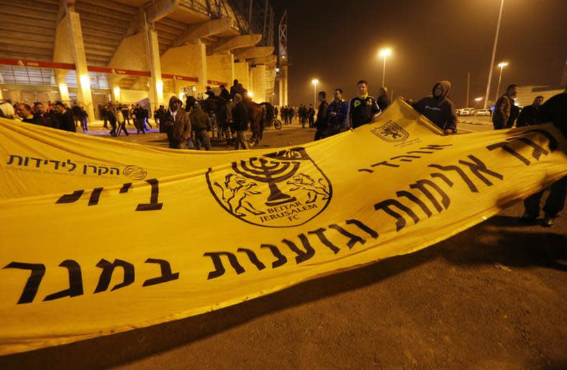 Beitar Jerusalem soccer fans hold a banner against violence and racism ahead of their team's match against Bnei Sakhnin in an Israeli Premier League game, at Teddy Stadium in Jerusalem February 10, 2013. The banner reads, "Against violence and racism in the field". REUTERS/Ronen Zvulun (photo credit: RONEN ZVULUN/REUTERS)