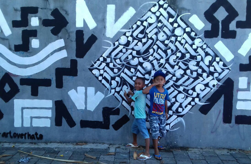 Children stand in front of an Artists for Israel mural in Indonesia (Craig Dershowitz) (photo credit: CRAIG DERSHOWITZ)