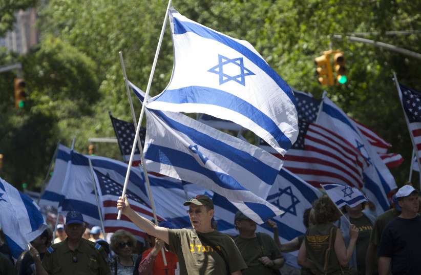 People hold flags during the Celebrate Israel parade in New York June 3, 2012 (photo credit: REUTERS)