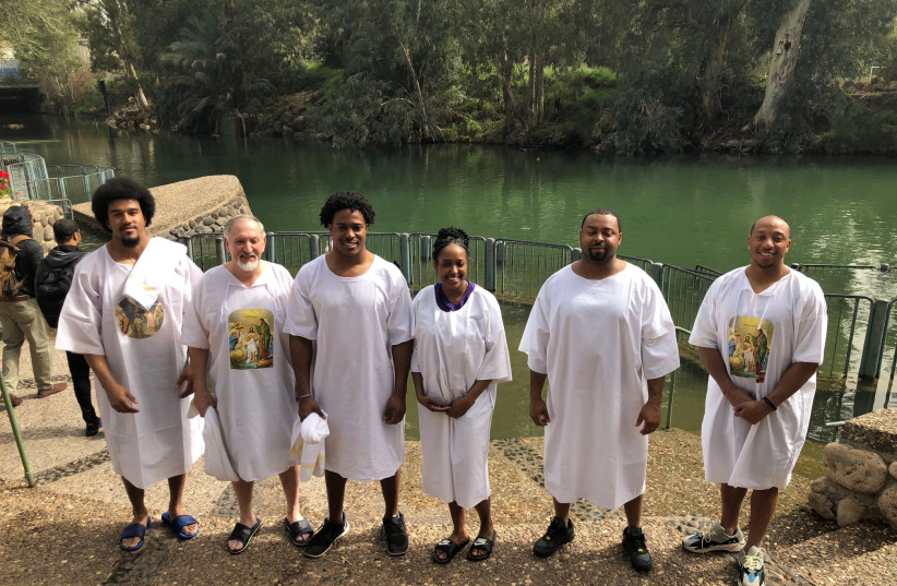 Christians, including NFL players (from left) Vic Beasley, Avery Williamson and Chris Harris Jr., prepare to be baptized at Yardenit on the Jordan River. (photo credit: COURTNEY FALLON/AMERICA’S VOICES IN ISRAEL)