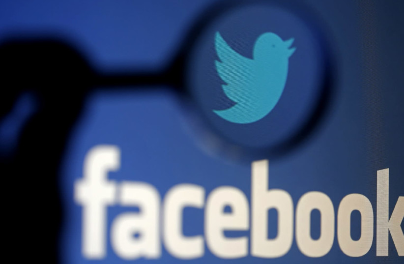 A LOGO of Twitter is pictured next to the logo of Facebook. (photo credit: REUTERS/DADO RUVIC/ILLUSTRATION/FILE PHOTO)