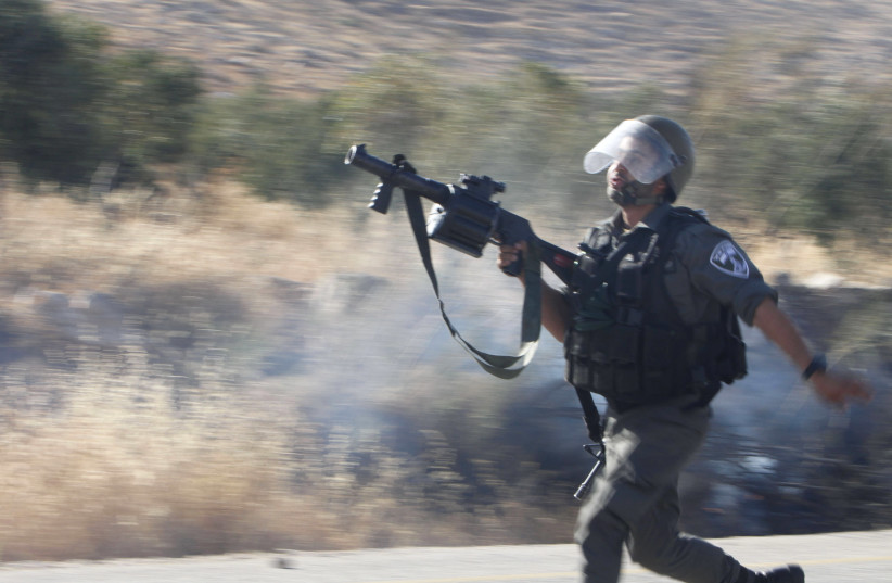 An Israeli border police officer runs during clashes with Palestinian protesters, August 8, 2015. (photo credit: REUTERS)