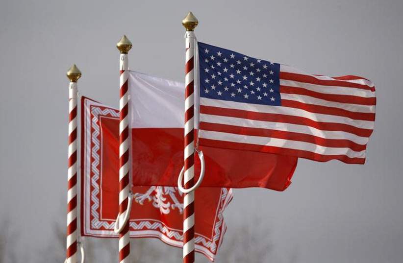 U.S. (R to L), Poland's flags and jack of the President of Poland are seen during the inauguration ceremony of bilateral military training between U.S. and Polish troops in Zagan, Poland, January 30, 2017. (photo credit: KACPER PEMPEL/REUTERS)