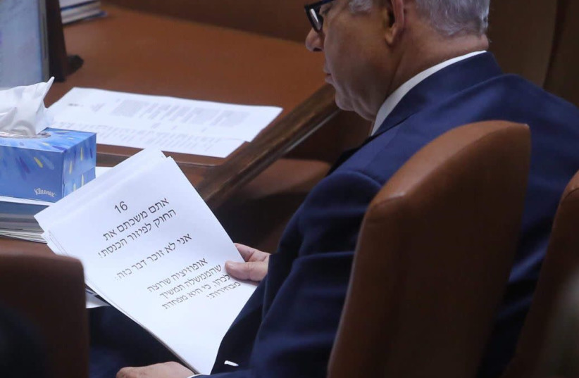 Prime Minister Benjamin Netanyahu reads from his speech in Knesset on March 12, 2018. (photo credit: MARC ISRAEL SELLEM/THE JERUSALEM POST)