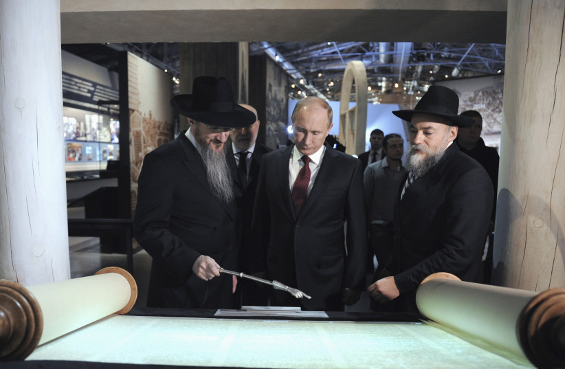 Russian President Vladimir Putin (C) listens to Russia's Chief Rabbi Berel Lazar (L) during his visit to the Jewish Museum and Tolerance Centre in Moscow February 19, 2013 (photo credit: SPUTNIK PHOTO AGENCY / REUTERS)