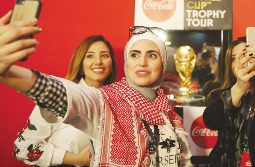 Soccer fans take selfies during the FIFA World Cup Trophy Tour last month in Amman, Jordan (photo credit: MUHAMMAD HAMED/REUTERS)