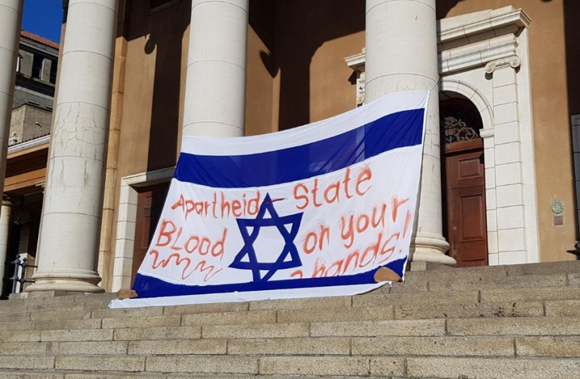 A bloodied Israeli flag hangs on the main building at the University of Cape Town on Monday at the start of Israel-Apartheid Week. (credit: SAUJS/FACEBOOK)