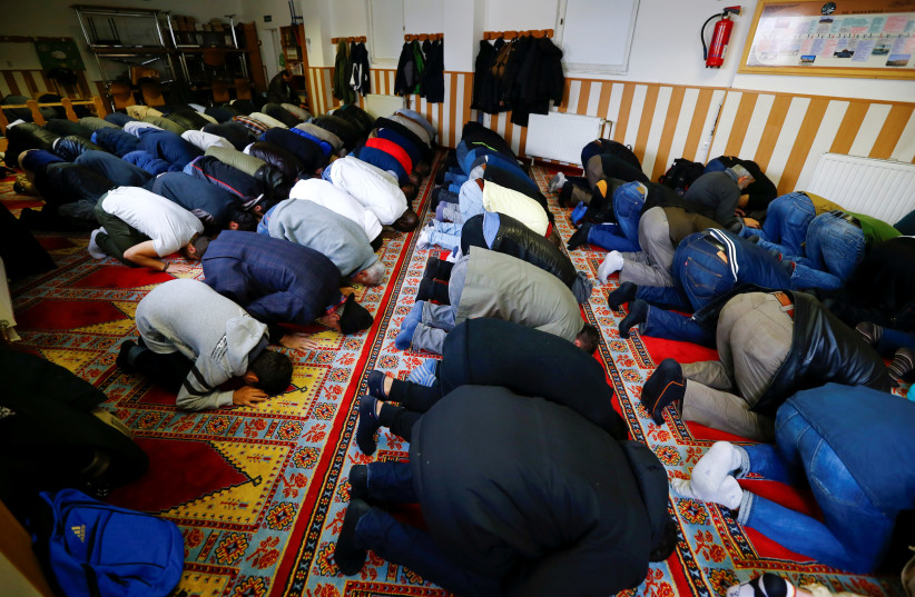 Muslims pray during Friday prayers at the Turkish Kuba Camii mosque located near a hotel housing refugees in Cologne's district of Kalk, Germany, October 14, 2016. Picture taken October 14, 2016. (photo credit: WOLFGANG RATTAY / REUTERS)