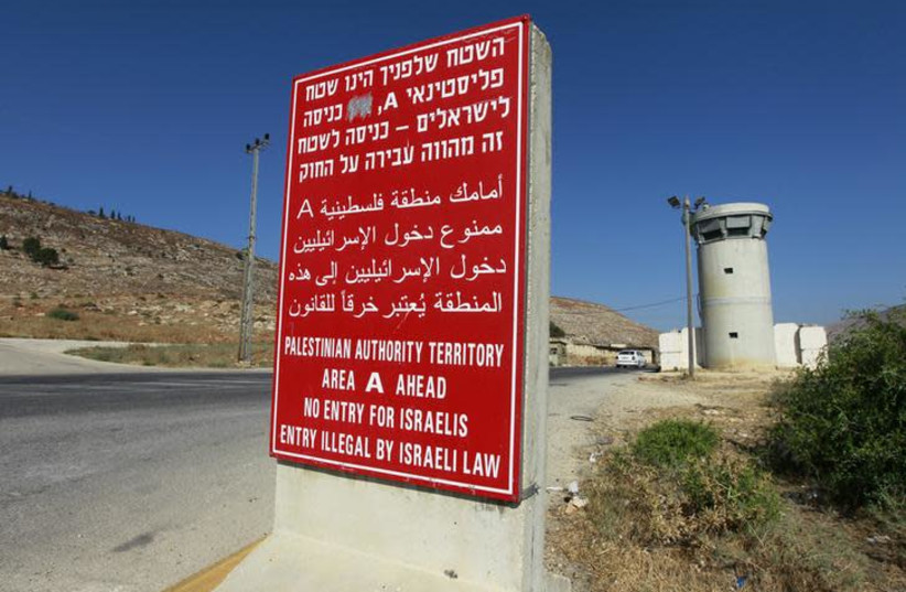 A sign stands at an Israeli checkpoint near the West Bank city of Nablus July 23, 2013. Israeli and Palestinian officials put forward clashing formats for peace talks due to resume in Washington on Monday for the first time in nearly three years after intense U.S. mediation. It is unclear how the Un (photo credit: BAZ RATNER/REUTERS)