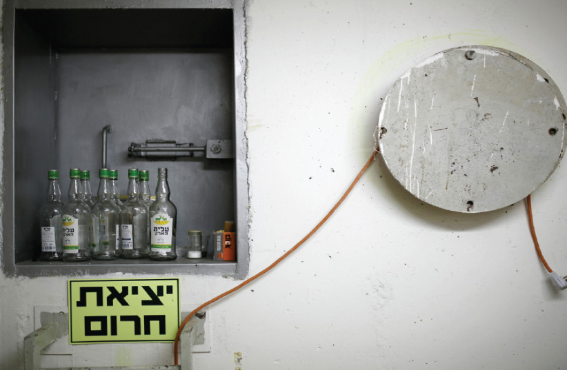 BOTTLES OF an alcoholic drink are seen in a bomb shelter in Ashkelon in 2014 (photo credit: AMIR COHEN/REUTERS)
