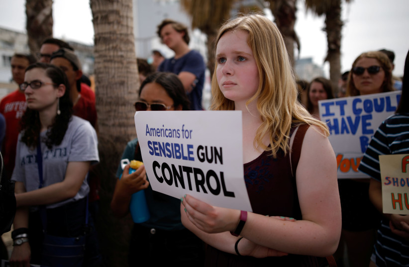 People protest in front of the US Embassy, calling for enhanced gun control in the US, in Tel Aviv, Israel, March 23, 2018 (photo credit: REUTERS/CORINNA KERN)
