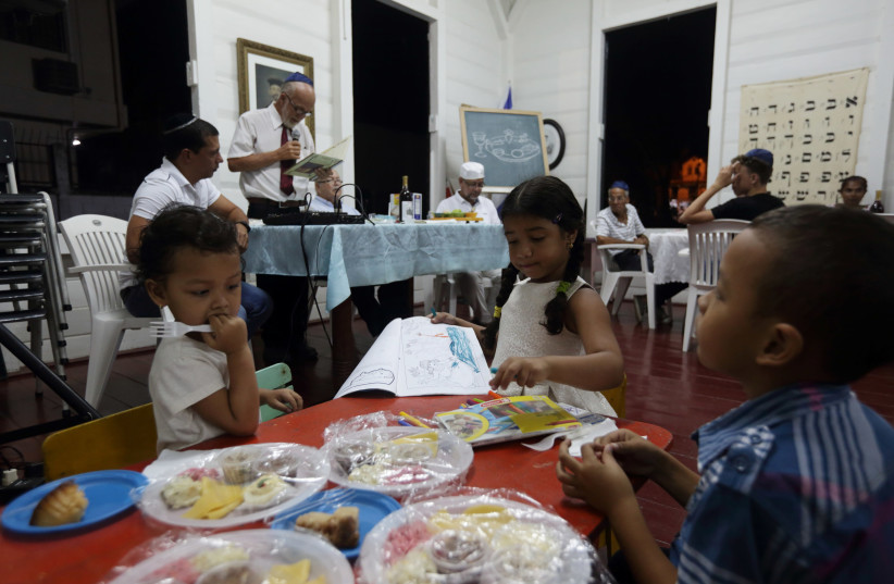 Surinamese Jews share the Passover Seder at the Neve Shalom Synagogue in Paramaribo, Suriname April 11, 2017. Picture taken April 11, 2017. (photo credit: RANU ABHELAKH/REUTERS)