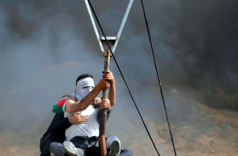 GAZANS POSITION a large slingshot to hurl stones at Israelis during clashes at the Israel-Gaza border, April 2018 (photo credit: MOHAMMED SALEM/REUTERS)
