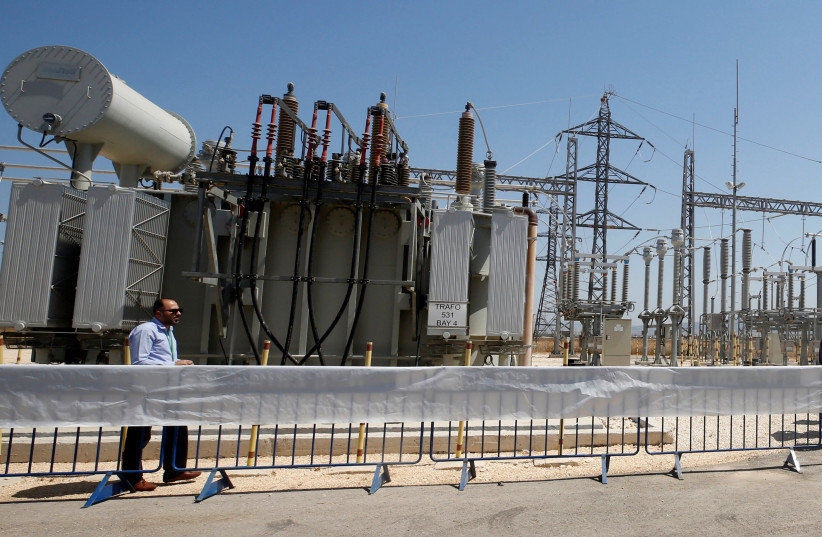 A worker walks in the new electrical substation near the West Bank city of Jenin July 10, 2017. (photo credit: ABED OMAR QUSINI/REUTERS)