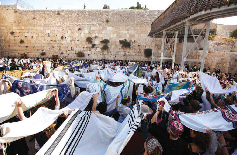Members of ‘Women of the Wall’ hold prayer shawls during a monthly prayer session at the Western Wall in Jerusalem’s Old City (photo credit: BAZ RATNER/REUTERS)