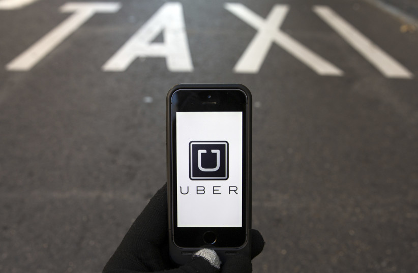 The logo of car-sharing service app Uber on a smartphone (photo credit: REUTERS/SERGIO PEREZ)