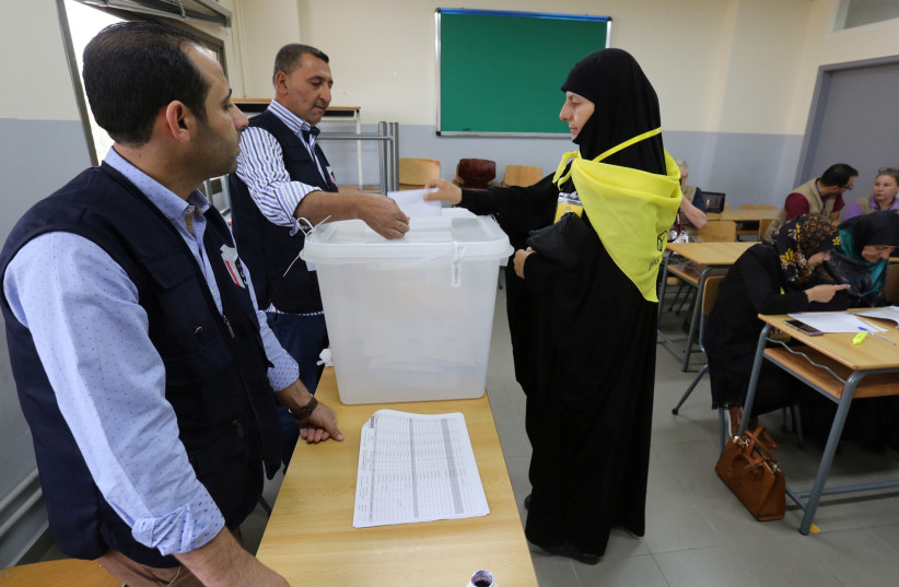 A woman supporter of Hezbollah casts her vote at a polling station during the parliamentary election in Tibnin, South Lebanon, May 6, 2018.  (photo credit: REUTERS/AZIZ TAHER)