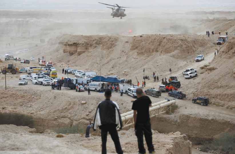 Israeli rescue service personnel operate near the site where 10 Israeli youths were swept away by a flash flood south of the Dead Sea on April 26 (photo credit: AMIR COHEN/REUTERS)