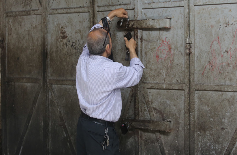 A Palestinian in the Old City of Jerusalem closing his shop in support of general strikes in West Bank and Gaza marking Nakba Day (photo credit: MARC ISRAEL SELLEM)