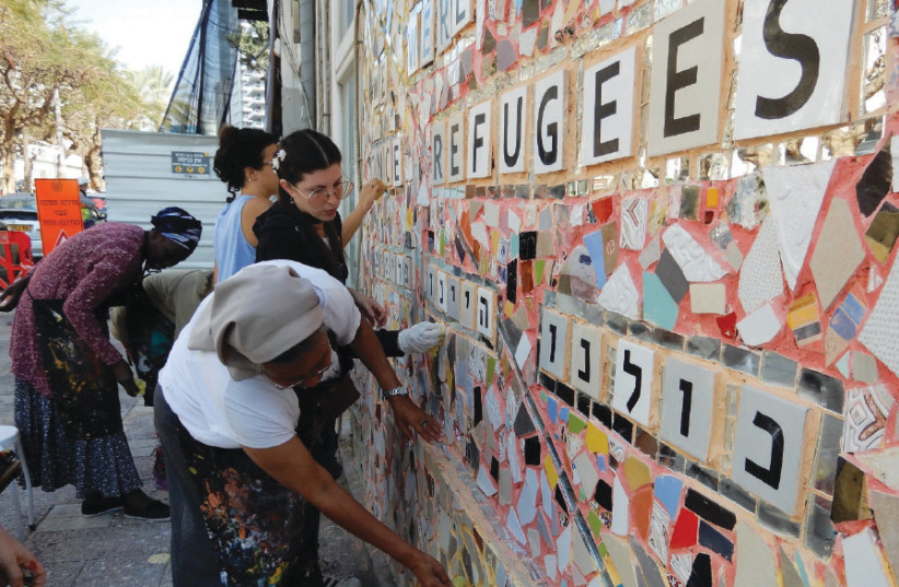  Volunteers from Kuchinate, an African refugee women’s collective, working on the ‘We Were All Once Refugees’ mosaic on Tel Aviv’s Rothschild Boulevard (photo credit: Courtesy)
