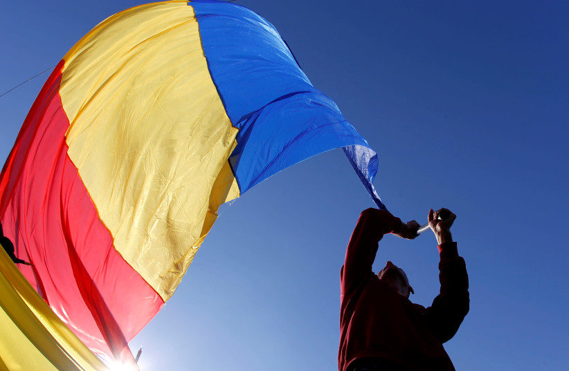 A man waves a Romanian national flag during a march in downtown Bucharest, Romania, October 20, 2013. (photo credit: REUTERS/BOGDAN CRISTEL)