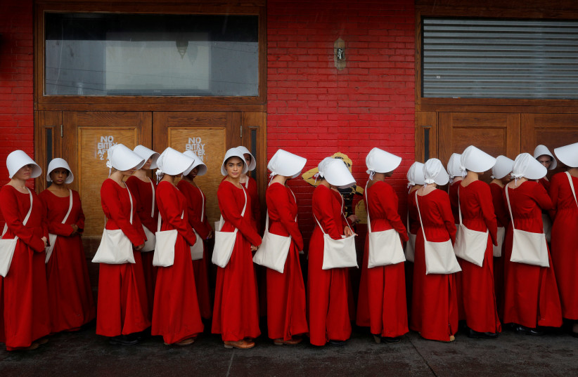 Women dressed as handmaids promoting the Hulu original series "The Handmaid's Tale" stand along a public street during the South by Southwest (SXSW) Music Film Interactive Festival 2017 in Austin, Texas, U.S., March 11, 2017. (photo credit: BRIAN SNYDER/REUTERS)