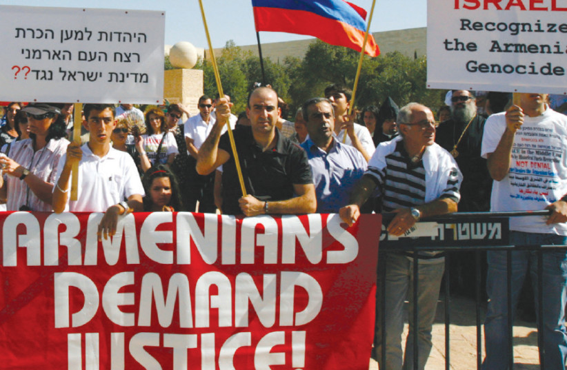 Members of the Armenian community in Israel attend a demonstration against Israel’s stance on the 1915 massacre of Armenians by Ottoman Turks outside the Foreign Ministry in Jerusalem; the sign on the left reads: ‘Judaism is for acknowledgement of Armenian Genocide, the State of Israel against?’ (credit: RONEN ZVULUN / REUTERS)