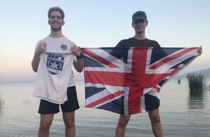 BENJI SIMON (left) and Avi Levy on the shore of the Kinneret with a ZAKA T-shirt and British flag. (photo credit: Courtesy)