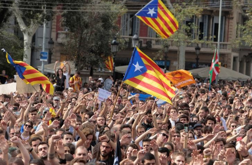 People shout as Esteladas (Catalan separatist flags) flutter during a protest the day after the banned independence referendum in Barcelona, Spain October 2, 2017 (photo credit: ENRIQUE CALVO/REUTERS)