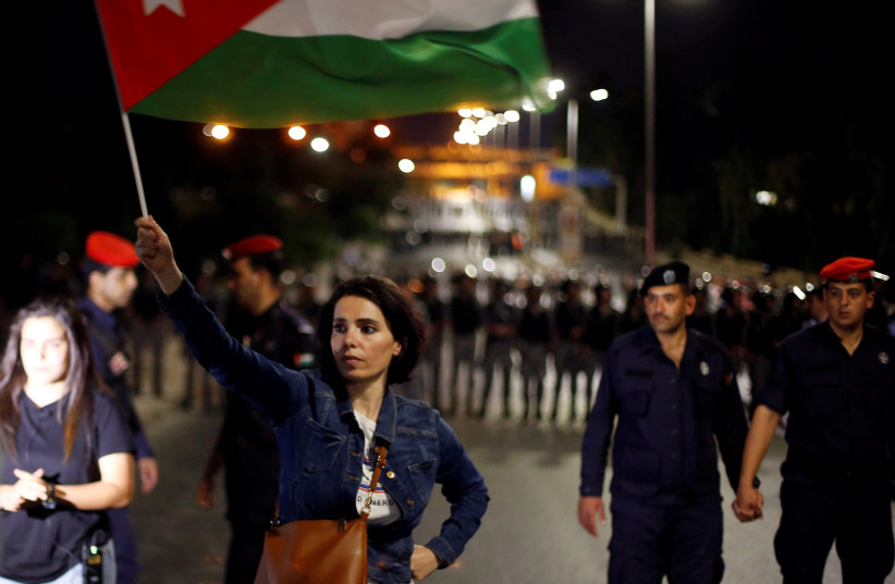 A protester holds up a Jordanian national flag during a protest in Amman, Jordan June 4, 2018 (photo credit: MOHAMMAD HAMED / REUTERS)