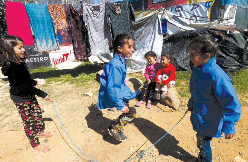 SYRIAN REFUGEE children play at a tented settlement in the town of Qab Elias, in Lebanon’s Bekaa Valley, on March 13 (photo credit: REUTERS)